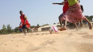 children playing football in the desert
